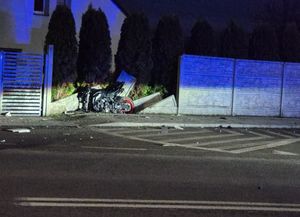 Uszkodzony motocykl przy ogrodzeniu posesji