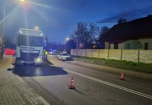 Miejsce wypadku drogowego. Po lewej stronie na chodniku stoi samochód ciężarowy