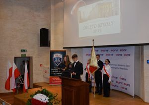 Poczet sztandarowy na scenie oraz młodzież podczas przemówienia