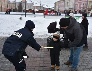 Policjantka daje odblask małemu chłopczykowi