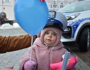 Mała dziewczynka w policyjnej czapce i z balonikiem w ręce