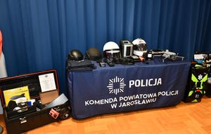 Policyjny sprzęt poukładany na stoliku w sali odpraw