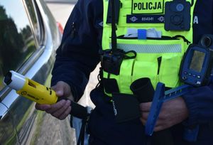 Policjant trzyma w ręce urządzenie do badania stanu trzeźwości