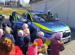 Dzieci z policjantami przy radiowozie