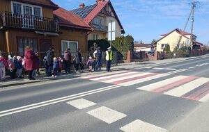 Policjant z dziećmi przy przejściu dla pieszych