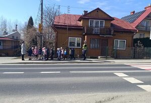 Dzieci z policjantem przy przejściu dla pieszych