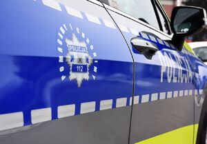 Zdjęcie części radiowozu z policyjną gwiazdą z napisem pomagamy i chronimy