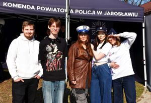 Młodzież w policyjnych czapkach przed policyjnym stoiskiem