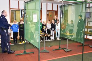 Policjanci z dziećmi na strzelnicy