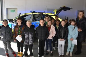 Zdjęcie grupowe dzieci i kobiety przed radiwozem