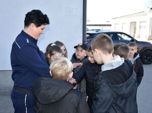 Policjantka częstuje dzieci cukierkami