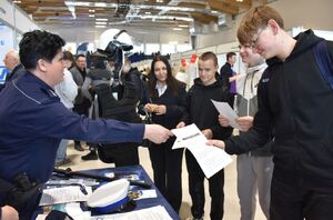 Osoby przy policyjnym stoisku