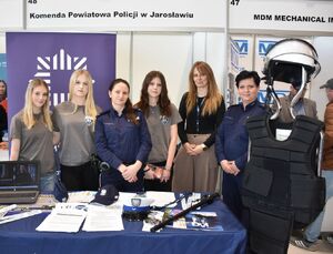 Zdjęcie grupowe młodzieży z policjantami przy policyjnym stoisku