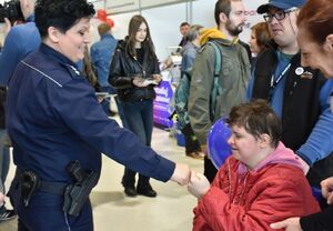 Policjantka przybija żółwika kobiecie siedzącej na wózku inwalidzkim