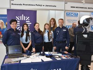 Policjanci z uczniami klas mundurowych przy policyjnym stoisku