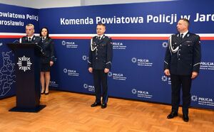 Policjant przy mównicy.