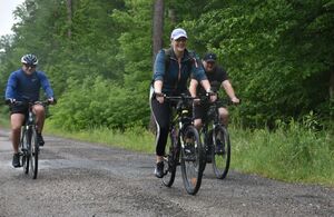 Rowerzyści jadą leśną drogą