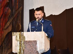 Policjant czyta podczas mszy św.