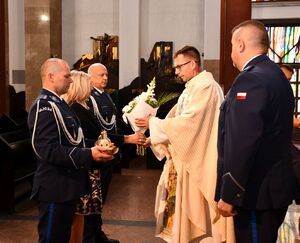 Policjanci składają dary kapłanowi