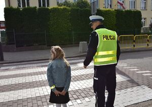 Policjant z dzieckiem na przejściu dla pieszych