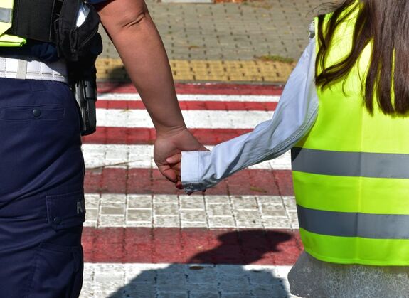 Policjantka trzyma dziewczynkę za rękę