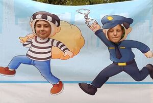 Dzieci na policyjnej ściance przedstawiającej złodzieja i policjanta