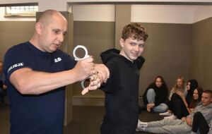 Policjant zakłada chłopcu kajdanki