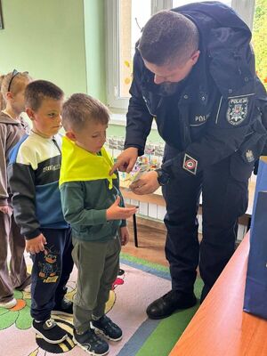 Policjant zawiązuje chłopcu chustę