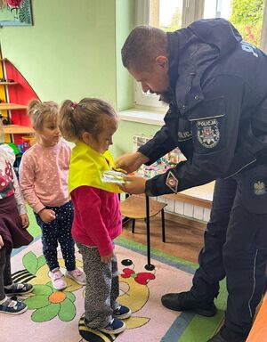 Policjant zawiązuje dziewczynce chustę